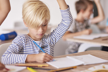 Boy drawing and rising his hand.