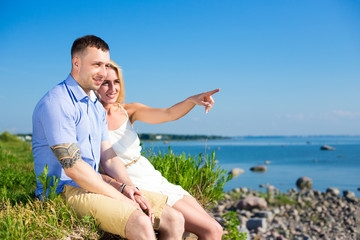 Naklejka na ściany i meble summer vacation concept - happy smiling couple enjoying sea view