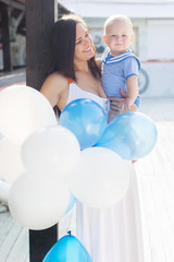 Mother and little son with balloons outdoors