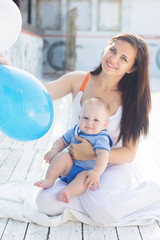 Mom and little child boy with balloons outdoors