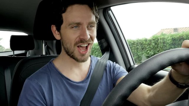 Cool happy man singing in car while driving 4K