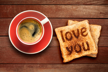 Breakfast, coffee and toast with the text love you, on a wood background