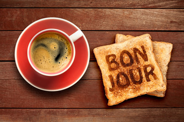 Breakfast, coffee and toast with the text bonjour, on a wood background © flydragon