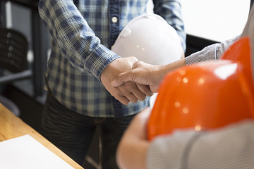 architect engineer shaking hands beside window - business teamwo