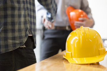 architect engineer shaking hands beside window - business teamwo