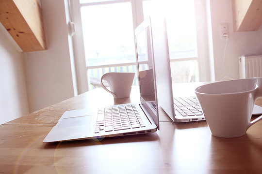Kaffee und Computer am sonnigen Morgen