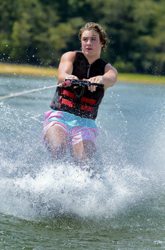 Close up of a teenage boy water skiing, he has been pulled up.