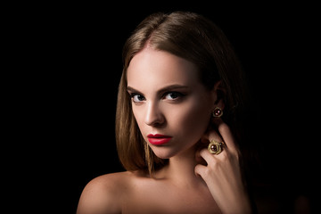 Beauty portrait of blond girl with jewelry on black background