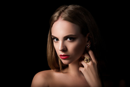 Beauty portrait of blond girl with jewelry on black background