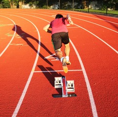 A sprinter explodes out of the blocks in a 200m race