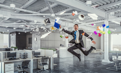 Jumping businessman in office . Mixed media