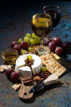 Camembert cheese, snacks and glasses of wine, vertical