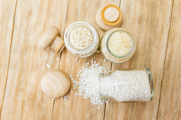 three kinds of uncooked rice in glass jars on a wooden table
