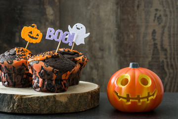 Halloween cupcakes and Halloween pumpkin on wooden background

