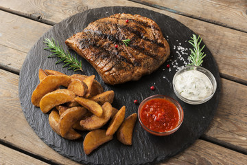 Beef steak with baked potato and sauce