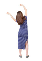 Fototapeta na wymiar back view of dancing young beautiful woman. girl watching. Rear view people collection. backside view of person. Isolated over white background.The brunette in a blue striped dress waving his