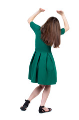 back view of woman  protects hands from what is falling from above. woMan holding a heavy load Rear view people collection.  backside view of person.  Isolated over white background. Slim brunette