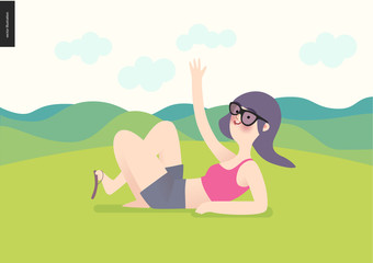 Obraz na płótnie Canvas Waving girl on green landscape background - a girl wearing sun glasses, magents top and grey shirts waves lying down on grass with hills landscape and light yellow sky on the background