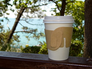  стакан с кофе на фоне зеленых деревьев и синего моря      © Valentina A