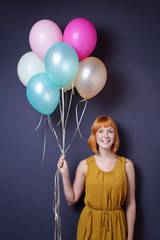 glückliche frau hält luftballons in der hand
