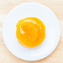 Close up texture of fluffy and glazed orange cake served on whit