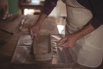 Fototapeta na wymiar Male potter designing clay