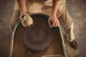 Male potter holding clay