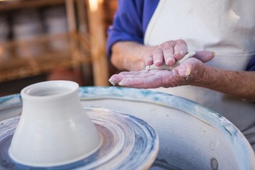 Mid section of potter making pot