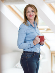 Mature bussines woman standing with the cup of coffe or tea on her rooftop office