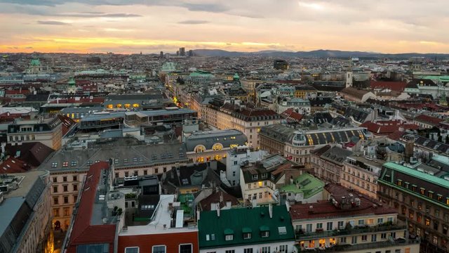 Aerial view of Vienna, Austria in the evening with sunset sky. Illuminated historical buildings at night. Time-lapse