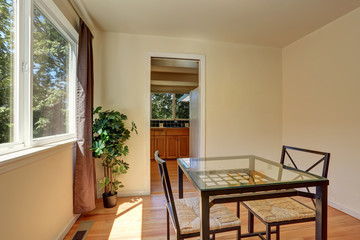 Dining wicker chairs with glass table by the window.