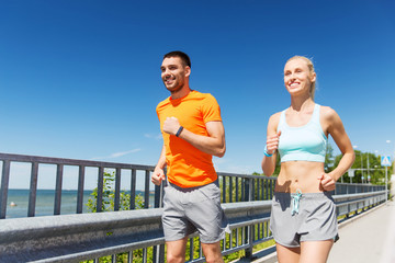 smiling couple running at summer seaside