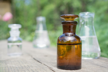 Liquid in chemical ware on a background of plants, fertilizers or pesticides in the garden.