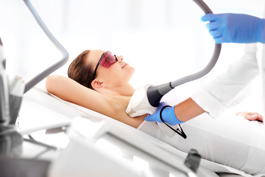 Depilacja laserowa pach. Kobieta na zabiegu depilacji laserowej