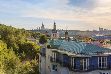 Obraz premium Церкви Андреевского монастыря на фоне достопримечательностей Москвы.
