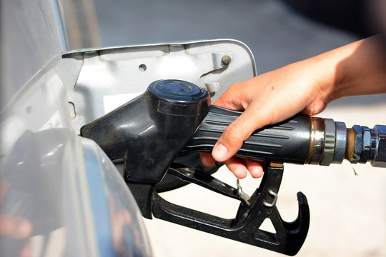  Pumping gas at gas pump. Closeup of man pumping gasoline fuel in car at gas station.