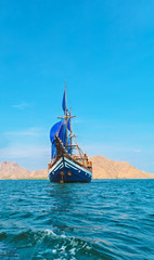 Vintage Wooden Ship with Blue Sails