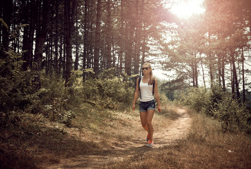 Young sporty female backpacking in the park in the morning. Concept of leisure activity and lifestyle.  