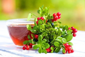 Cup of tea, cranberries and blueberries. Selective focus 