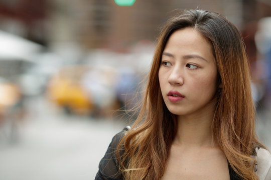 Young Asian woman in city serious face portrait
