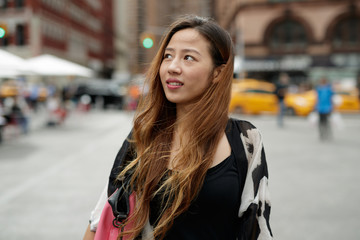 Young Asian woman in city walking smile happy face
