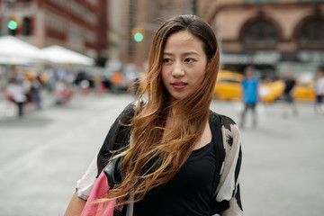 Young Asian woman in city walking smile happy face
