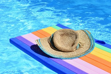 Fototapeta na wymiar Pool with clean water. Hat, sun glasses on air mattress lilo. Summer background for traveling and vacation.