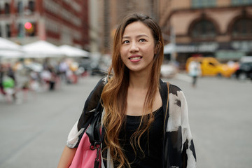 Young Asian woman in city walking smile happy face
