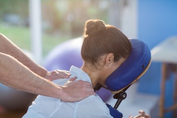 Physiotherapist giving shoulder massage to a female patient