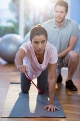 Physiotherapist assisting a female patient while exercising