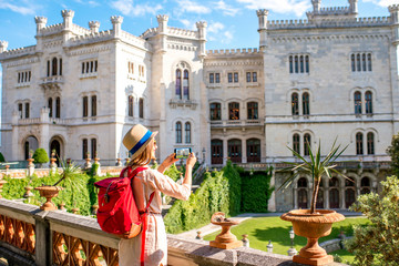 Young female traveler enjoying beautiful landscape near Miramare castle in northeastern Italy....