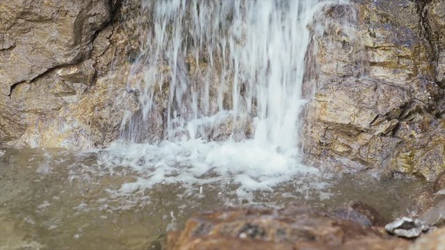 Wasserfall eines Baches im Gebirge, mit sauberem und klarem Wasser aus einer Quelle im Gestein. Erfrischendes Quellwasser für Wanderer in den bayerischen Bergen und Alpen.