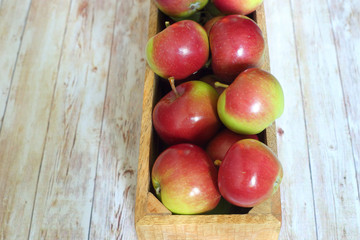 fresh red apples in wooden box on a wooden background