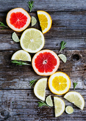 Fresh citrus, cut into pieces and slices on wooden background